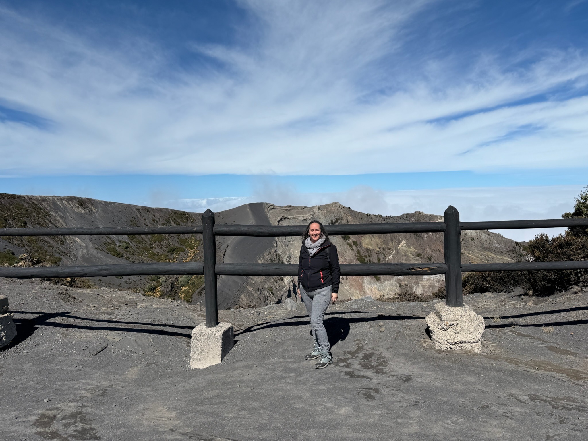 Une voyageuse posant au sommet du Volcan Irazu pendant un voyage au Costa Rica
